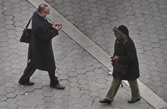 This Tuesday, Jan. 4, 2011 photo shows a pedestrian walking while using a phone in New York. While smartphones and other electronic devices changed popular culture by offering an ability to always stay connected, it so swiftly turned into such a compelling need that a simple walk down the street is considered wasted time. (AP Photo/Bebeto Matthews)